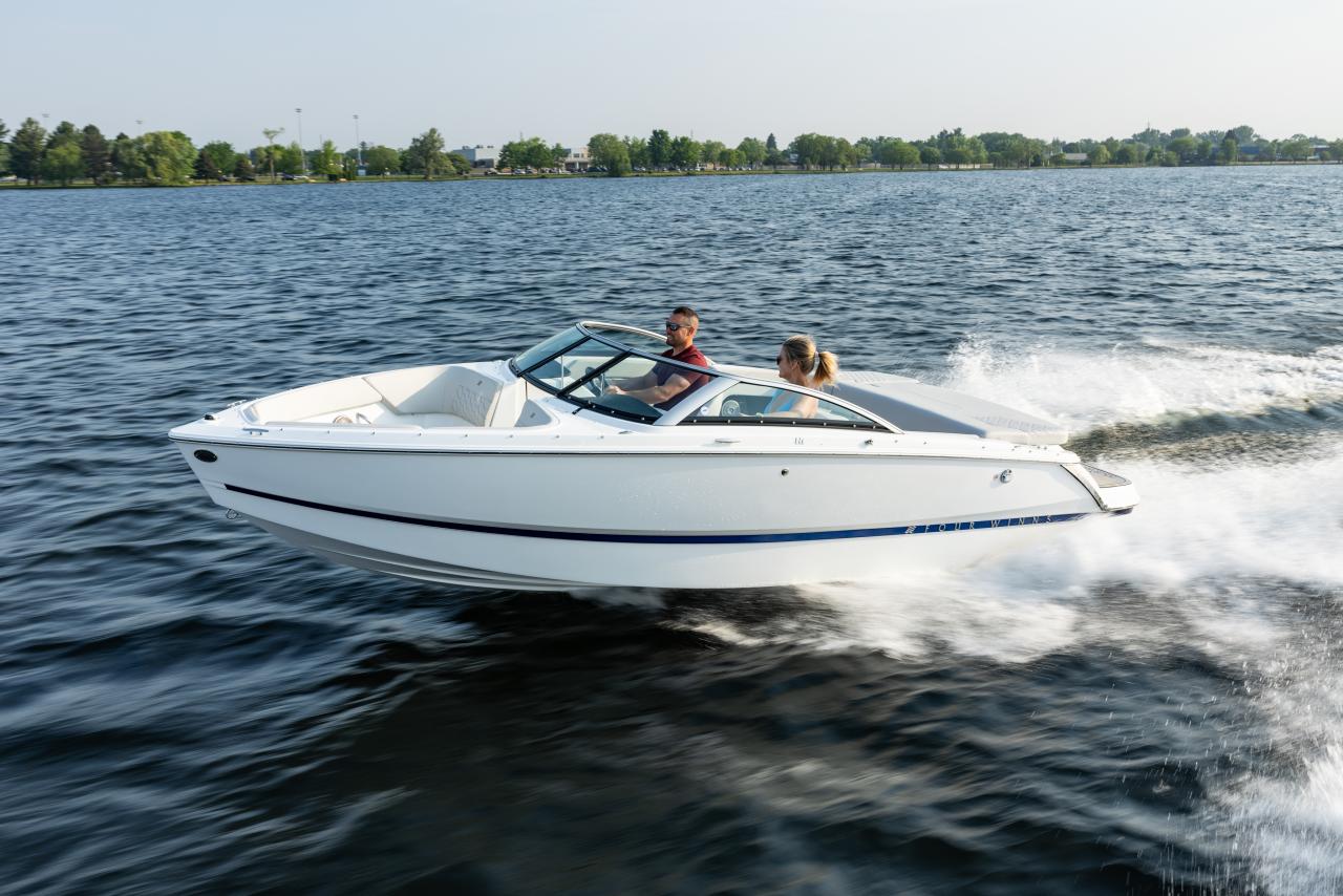 Four Winns H1 Horizon Freedom IO bowrider cruising on lake – 20’ model with Mercury inboard/outboard, available at Lark Marine
